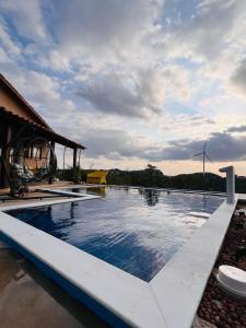 ein Swimmingpool vor einem Haus mit einer Windmühle in der Unterkunft Margarida 04 in Monte das Gameleiras + 8 Fotos