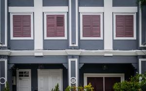 a blue and white building with brown shuttered windows at Aayu Church St - 7 mins to Esplanade, George Town in George Town