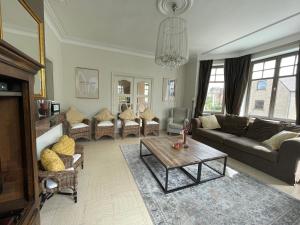 een woonkamer met een bank en een tafel bij Villa Dageraad in De Panne