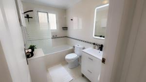 ロス・アルカサレスにあるCasa Riveroの浴槽、トイレ、洗面台を備えた白いバスルーム +15枚の写真