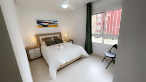 ロス・アルカサレスにあるCasa Riveroのベッドと窓のある白い寝室