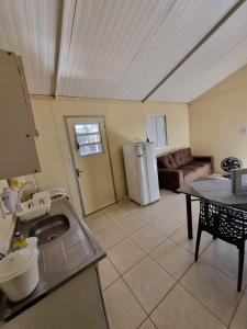 a kitchen with a sink and a living room at Condomínio Gold in Três Lagoas +17 photos