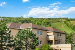a house with a mountain in the background at 3 Bedroom Mountain Walk Condo, Steps to Village in Blue Mountains
