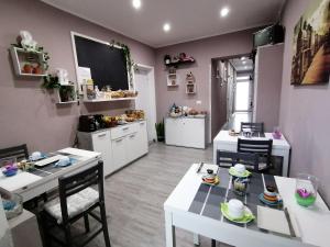 a kitchen with white tables and chairs in a room at Dimora Bed and Breakfast in San Gavino Monreale +14 photos