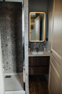 a bathroom with a sink and a mirror at Gîte Le Mora in Barfleur