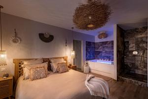 Un pat sau paturi într-o cameră la Suite balnéo Bali Saint-Étienne