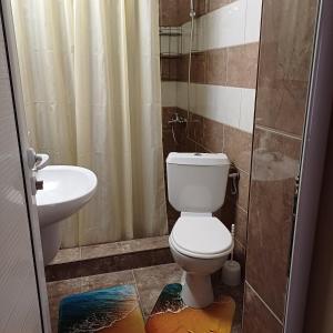 a bathroom with a toilet and a sink at Enjoy Guest House in Golden Sands
