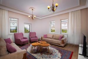 a living room with a couch and chairs and a table at Cappadocia Essa Orange Stone House in Nevsehir