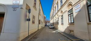 an empty alley way between two buildings with cars parked at Tomcat in Zagreb