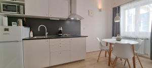 a kitchen with a table and a white refrigerator at Tomcat in Zagreb