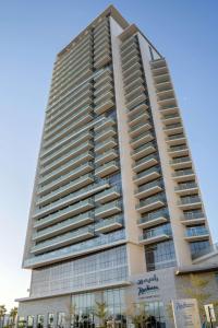 a tall building with a lot of windows at Radisson Dubai Damac Hills in Dubai