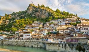 a town on a hill next to a body of water at Berat GuestHouse "AAA" in Berat