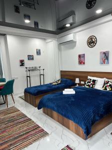 Dos camas en un dormitorio con sábanas azules. en Kutaisi Apartment, en Kutaisi 24 fotos más