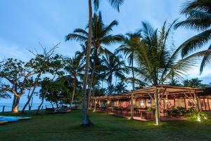 a resort with palm trees in front of a building at Reserva Jacumã Boutique Hotel in Trancoso