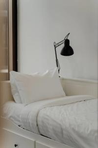 - un lit blanc avec une lampe au-dessus dans l'établissement Town Centre Cozy 2 Bed 1 Bath with Free Parking, à Belconnen