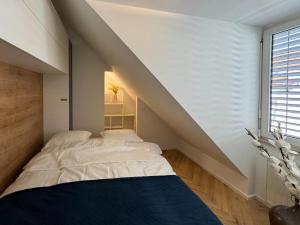 a attic bedroom with two beds and a staircase at Apartma Tyrseva in Maribor