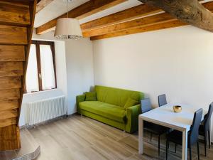 a living room with a green couch and a table at Duplex in casa rurale con cortile privato in Lugano