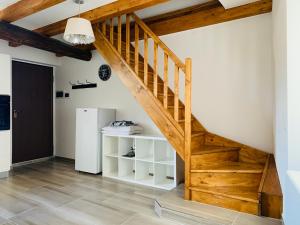 a wooden staircase in a room with a refrigerator at Duplex in casa rurale con cortile privato in Lugano