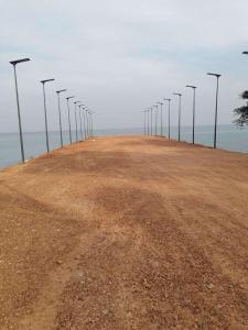 a row of street lights on a pier next to the ocean at Sweet Time Bungalows in Koh Rong Sanloem