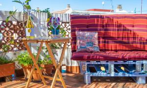 un sofá rojo sentado en un patio con una mesa en Casa Vilamurada - Duplex frente Castillo Dénia - By Marina Alta Holidays, en Denia