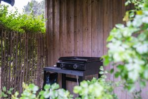 a grill sitting on a table in front of a fence at Villa Madonne - Piscine - Plage in Lège-Cap-Ferret