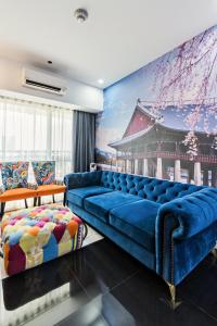 a living room with a blue couch and a painting at Makati City Centre Condo in Manila