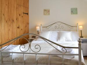une chambre avec un lit blanc avec des oreillers blancs dans l'établissement Annie's Cottage, à Duddon