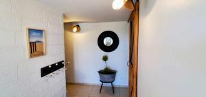 a hallway with a chair and a mirror on the wall at L'abreuvoir de la Mer- villa - plage in Sangatte +57 photos