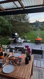 a wooden table with food on a patio with a grill at Kurkse KUUR in Kurkse