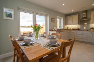 a kitchen with a wooden table with a vase of flowers at Crann Darach Cottages in Artikelly
