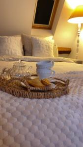 a tray with a tea set on a bed at La Perle Semuroise in Semur-en-Auxois