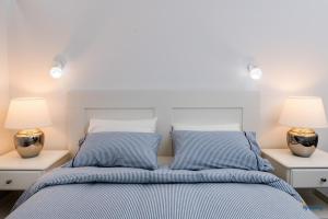 a bedroom with a bed with blue sheets and two lamps at Blue Beach in Playa del Ingles