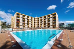 a swimming pool in front of a hotel at Blue Beach in Playa del Ingles