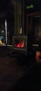 a stove with a fire inside of it at night at O Poleiro do Xurés in Maus de Salas +36 photos