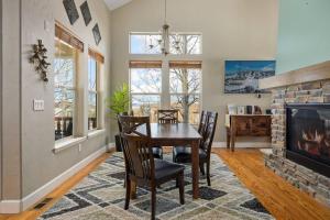 a dining room with a table and chairs and a fireplace at Timber Court in Granby