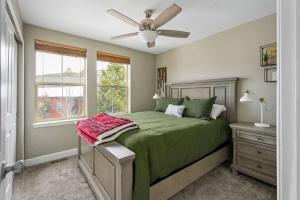 a bedroom with a green bed and a ceiling fan at Timber Court in Granby