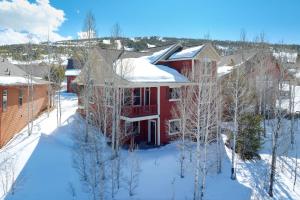 a red house with snow on top of it at Timber Court in Granby