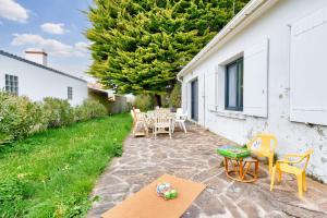 a patio with a table and chairs and a yard at Maison pour 6 avec jardin - 800 m de la plage in La Guérinière