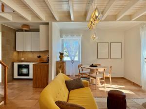 a living room with a yellow couch and a table at Musa do Pico in Madalena