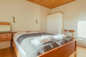 een slaapkamer met een bed met handdoeken erop bij 3 BR House - Parking - 10min walk from city centre in Tórshavn
