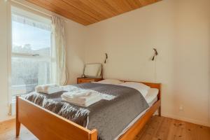 een slaapkamer met een bed met twee handdoeken erop bij 3 BR House - Parking - 10min walk from city centre in Tórshavn