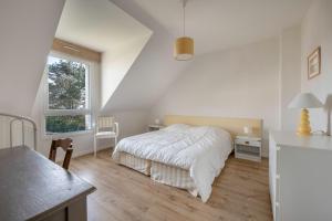 a bedroom with a bed and a desk and a window at A 150m de la plage, jolie maison avec jardin pour 10 in Saint-Sébastien