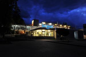 a building with a blue sign on it at night at Penzion Anesis - štúdiá in Turčianske Teplice