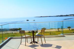 a table and chairs on a balcony with a view of the ocean at Amphora Hotel & Suites in Paphos