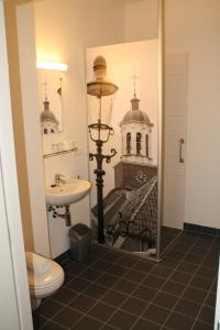 La salle de bains est pourvue d'un lavabo et d'une photo d'un bâtiment. dans l'établissement Stadshotel Ootmarsum, à Ootmarsum