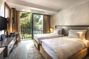 two beds in a hotel room with a balcony at Unique Life Style Hotel in Kuşadası +84 photos