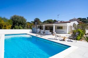 a swimming pool with chairs and a house at Enotria Villas - Tramonto sullo Stromboli in Capo Vaticano