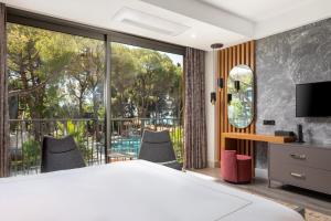 a bedroom with a bed and a large window at Unique Life Style Hotel in Kuşadası