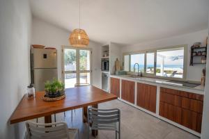 a kitchen with a table and chairs and a refrigerator at Enotria Villas - Tramonto sullo Stromboli in Capo Vaticano