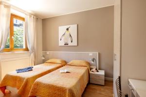a bedroom with two beds and a picture of a penguin at Residenza Marano 2B in Cupra Marittima +42 photos